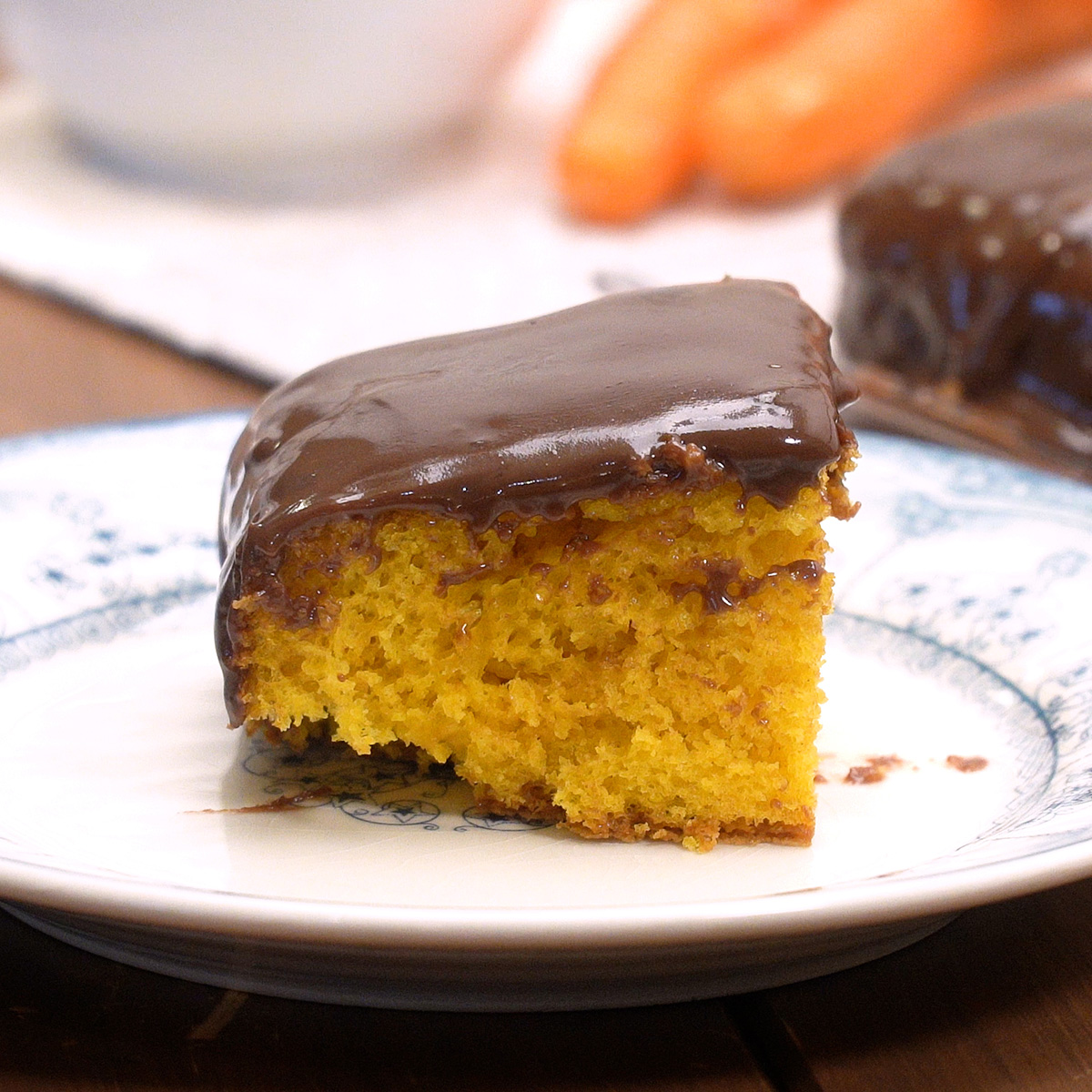 Bolo de cenoura com cobertura de chocolate servido em fatias.