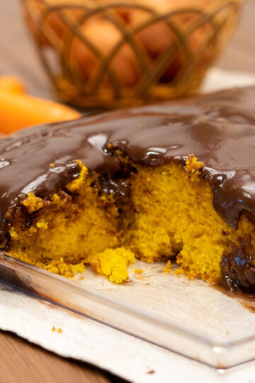Bolo de cenoura com cobertura de chocolate pronto sendo servido.