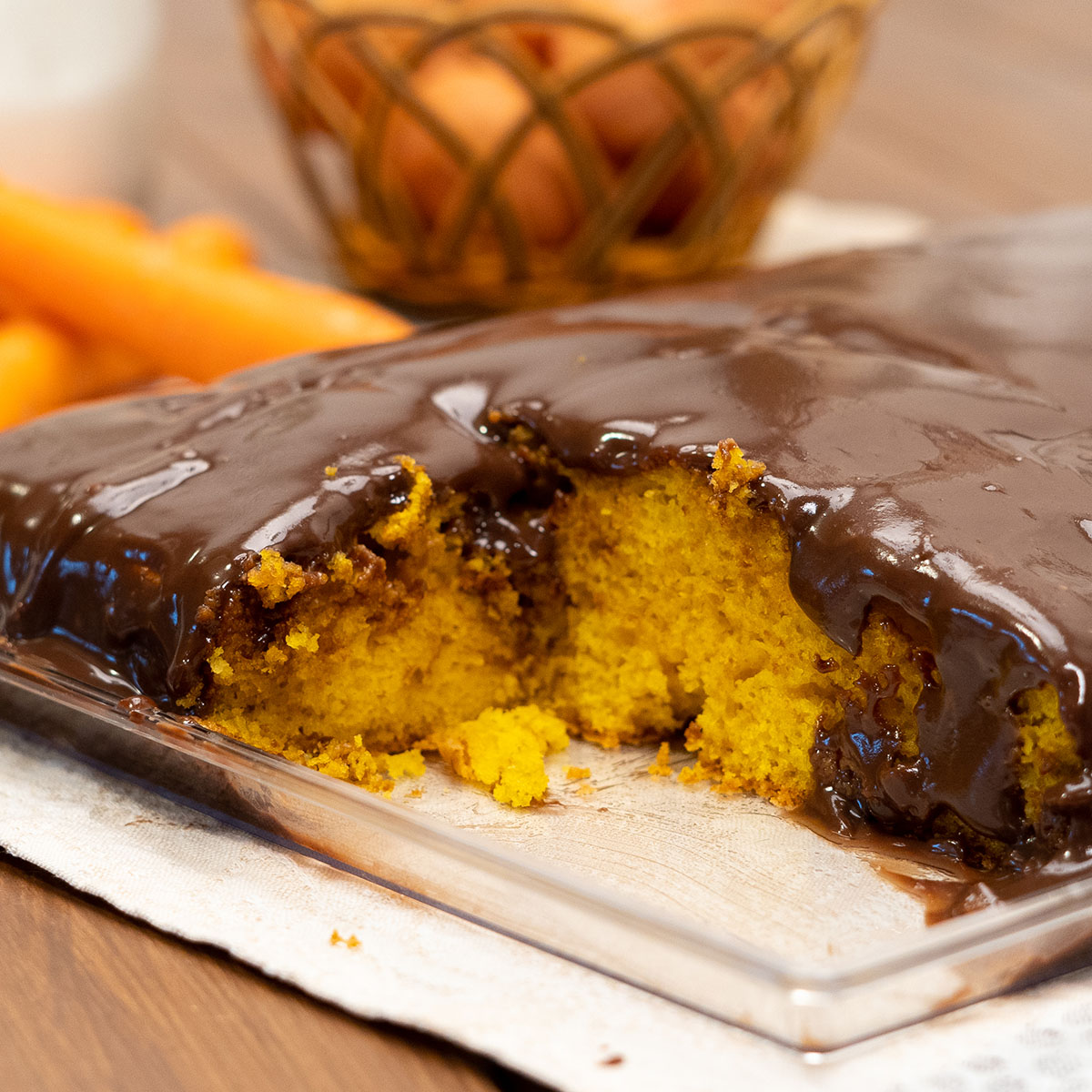 Bolo de cenoura com cobertura de chocolate pronto sendo servido.