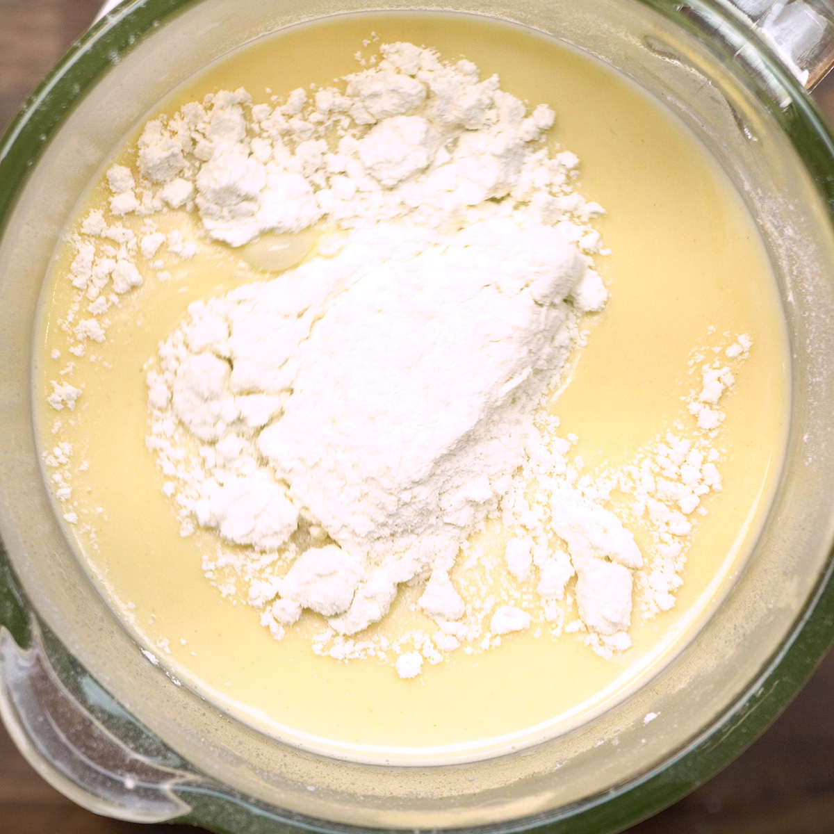 Massa de bolo de chocolate ficando lisa após a adição completa da farinha.