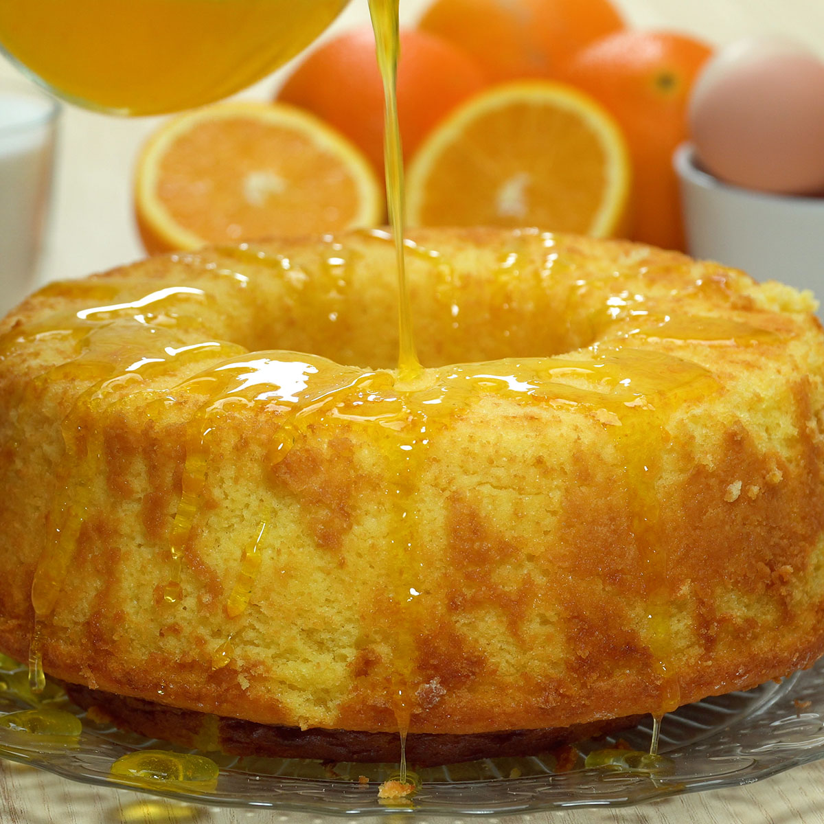 Bolo de laranja coberto com calda cítrica e raspas de laranja.