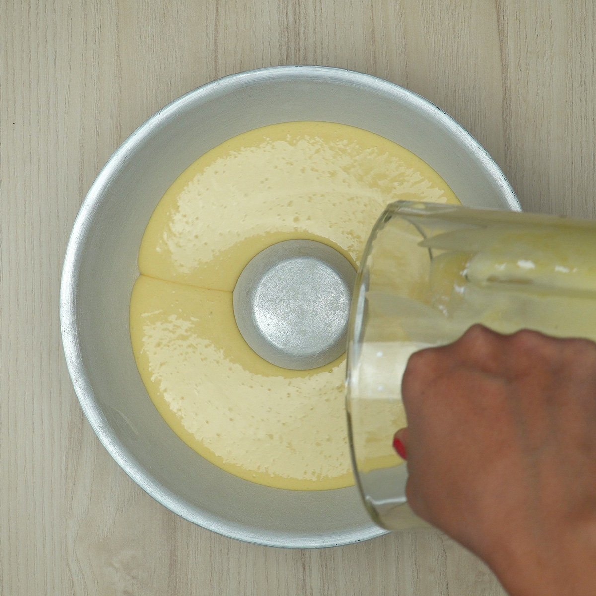 Massa de bolo de laranja colocada em forma redonda untada.