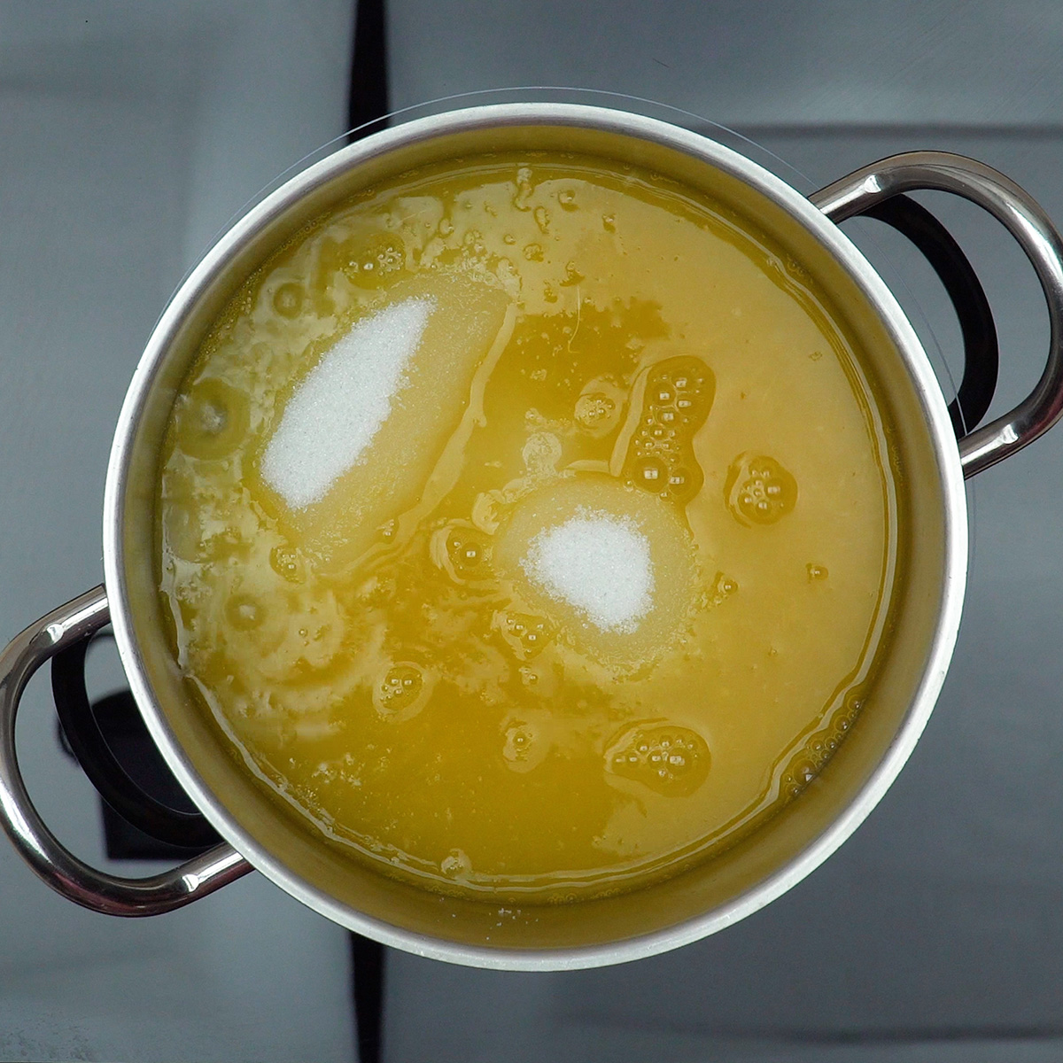 Calda de laranja sendo preparada em uma panela no fogão.