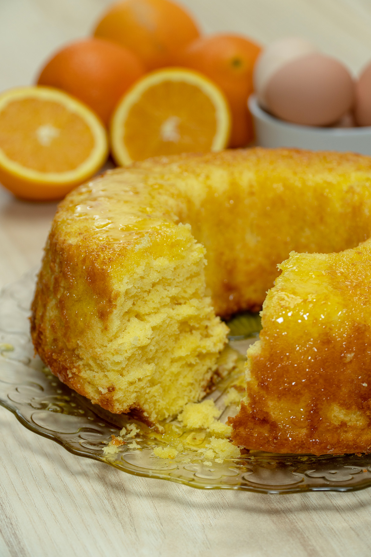 Bolo de laranja com calda de açúcar sendo servido.