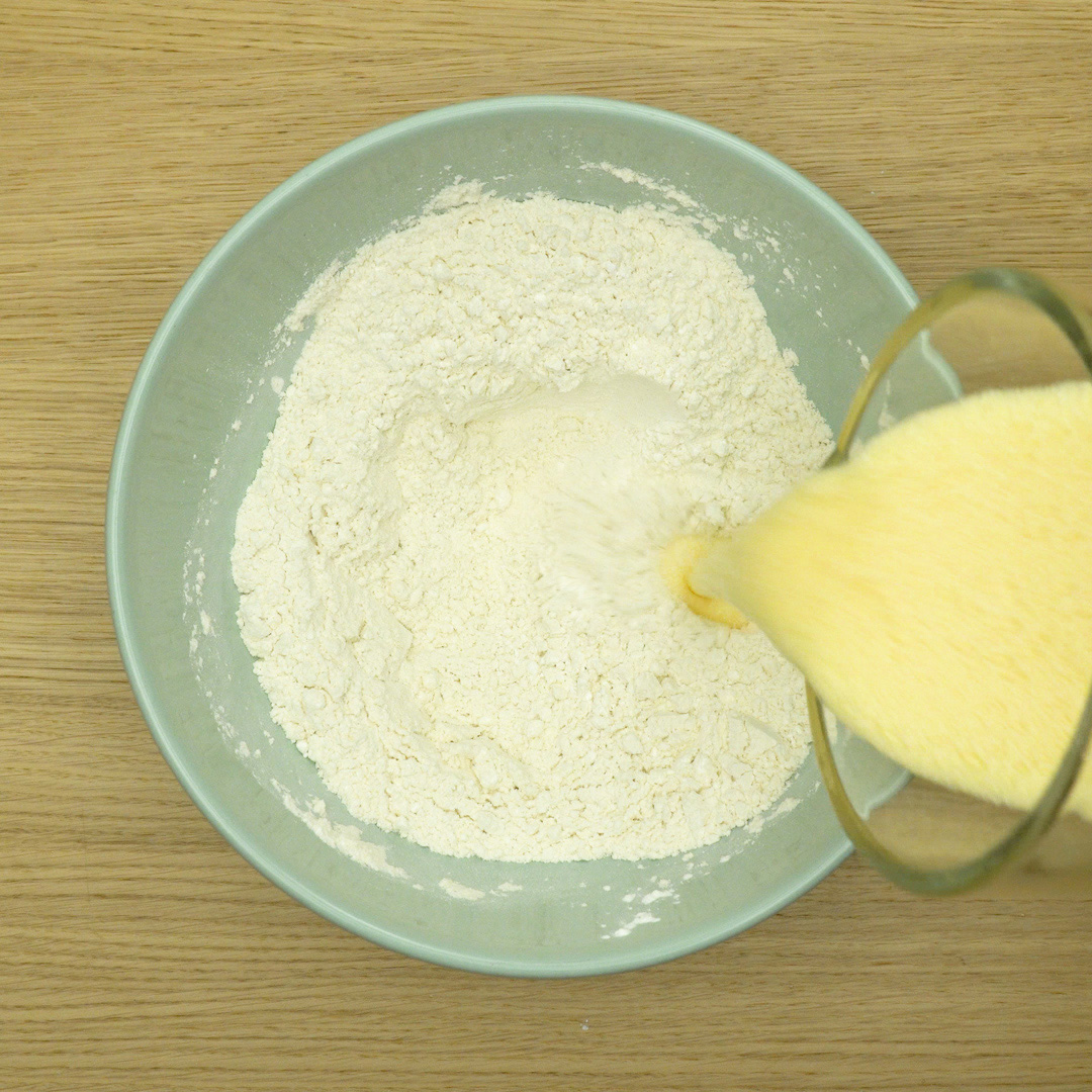 Massa branca do bolo mesclado sendo misturada com fouet.