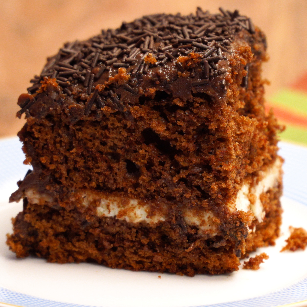 Bolo prestígio finalizado com cobertura de chocolate e granulado.