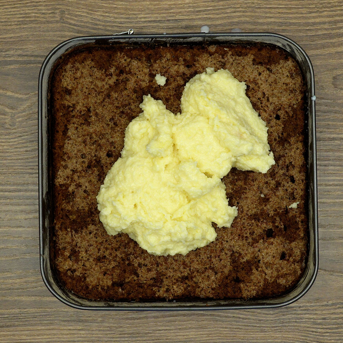 Montagem do bolo prestígio com recheio de coco entre as camadas.