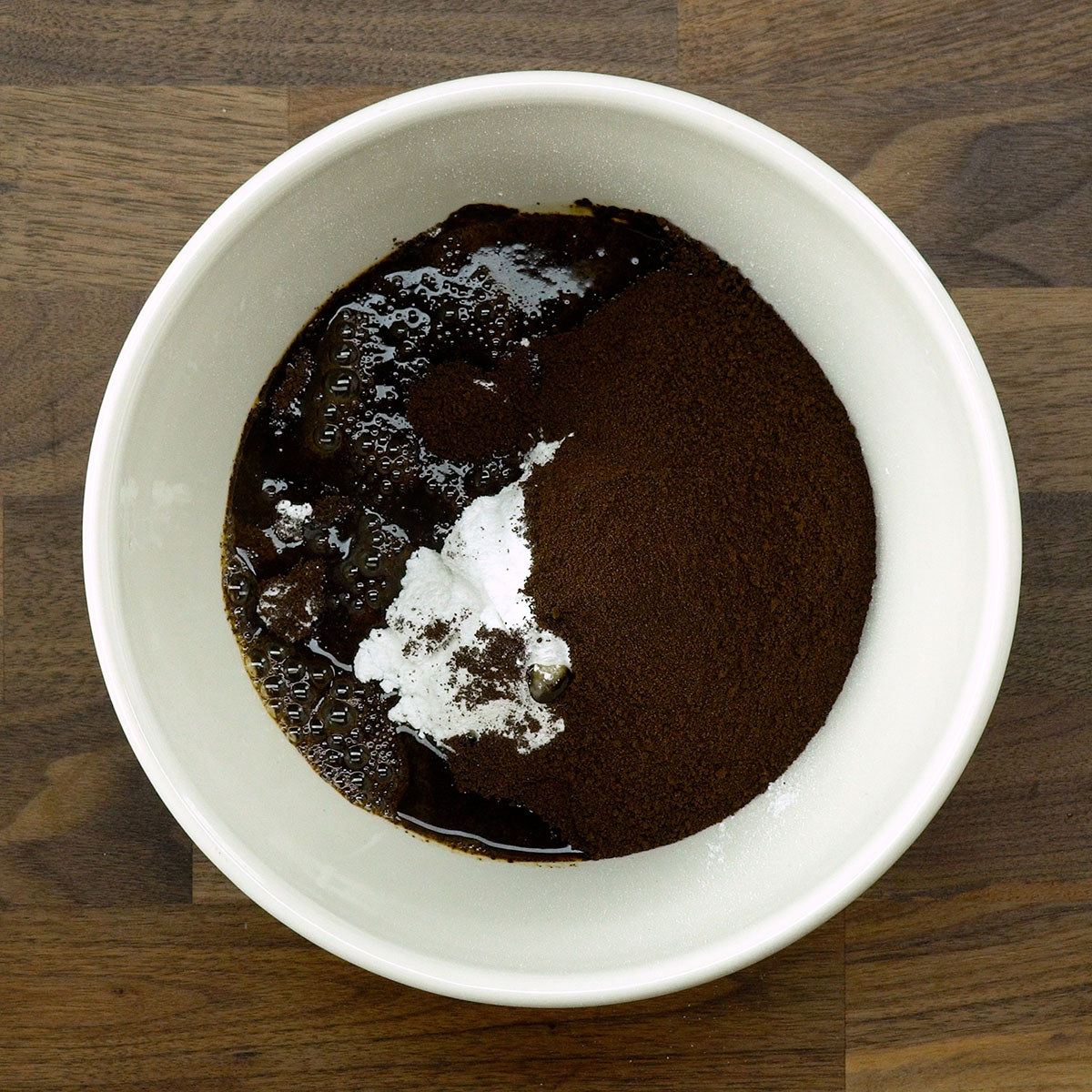 Café solúvel, açúcar e água quente na tigela da batedeira.