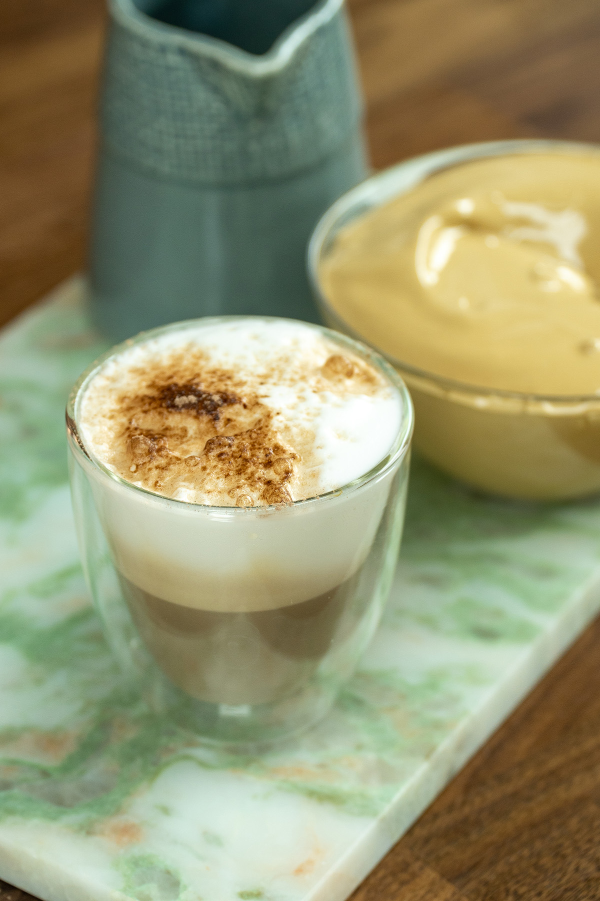 Café cremoso polvilhado com chocolate servido no copo.