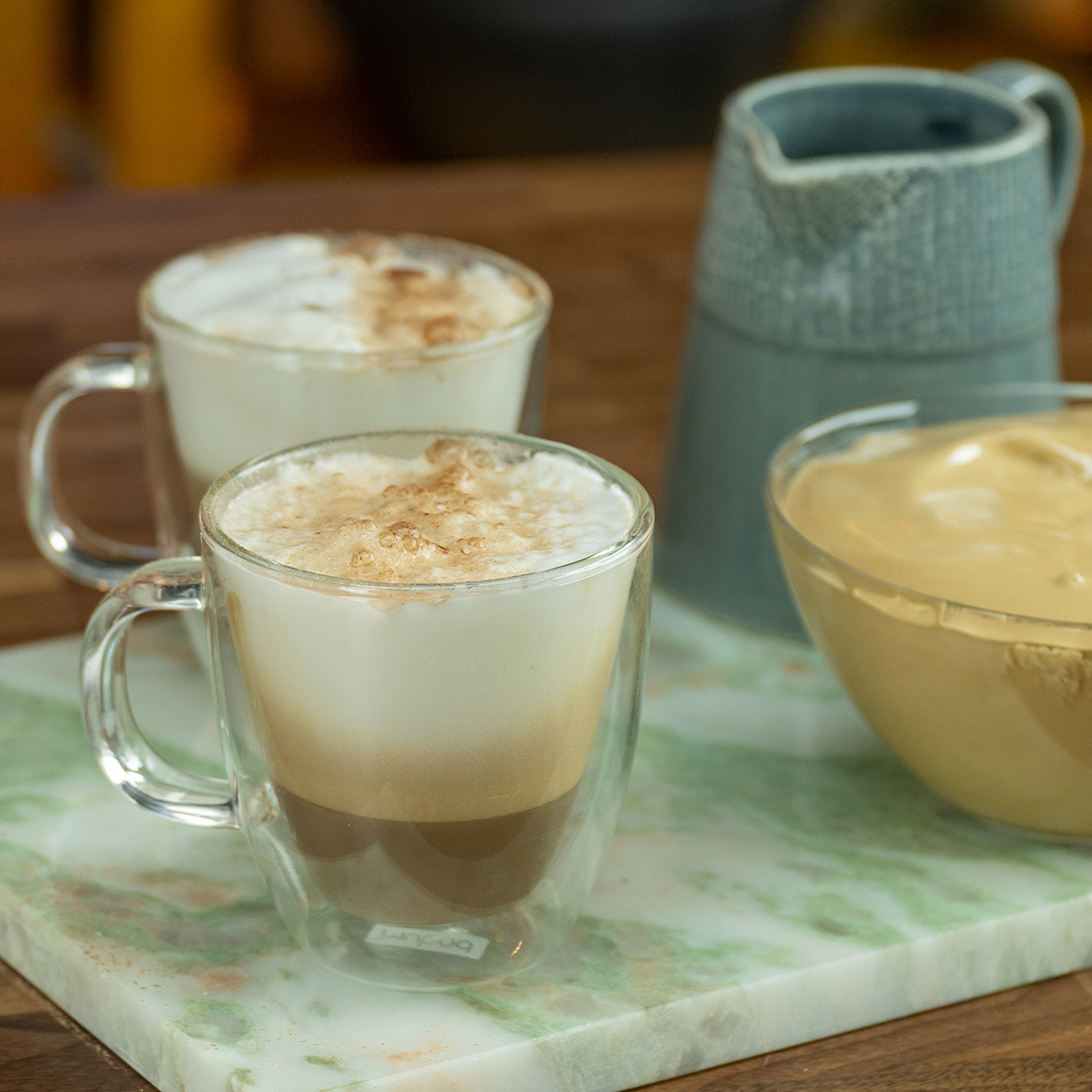 Café cremoso polvilhado com chocolate servido no copo.