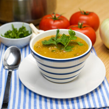 Caldo de fubá com carne moída pronta com erva de decoração.