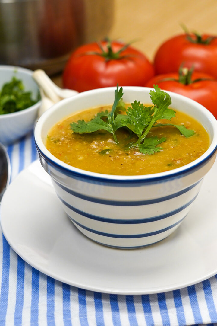 Caldo de fubá com carne moída pronta com erva de decoração.