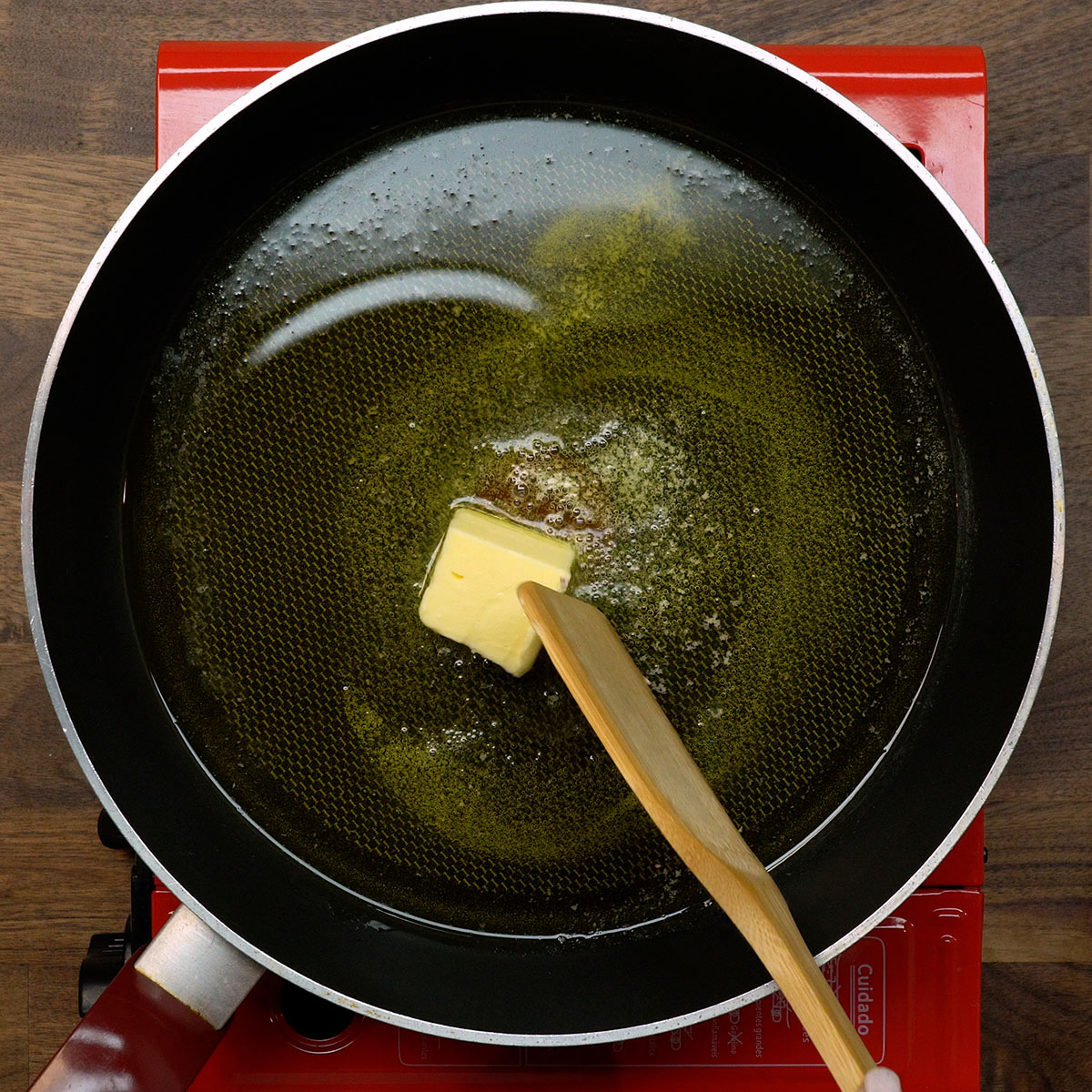 Manteiga derretendo na frigideira com azeite.