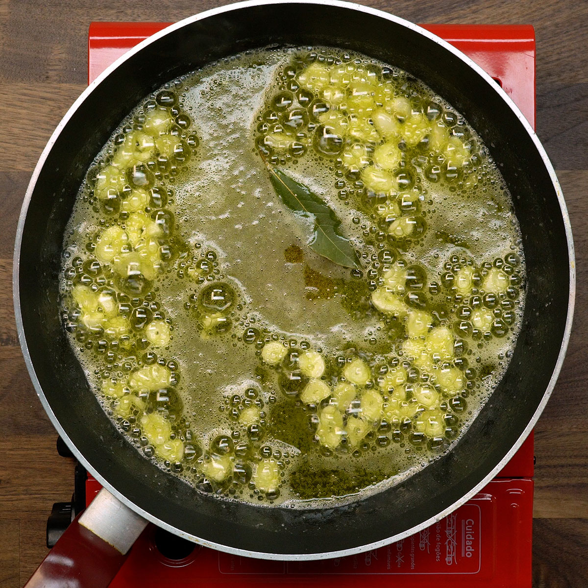 Alho laminado refogando com folha de louro.