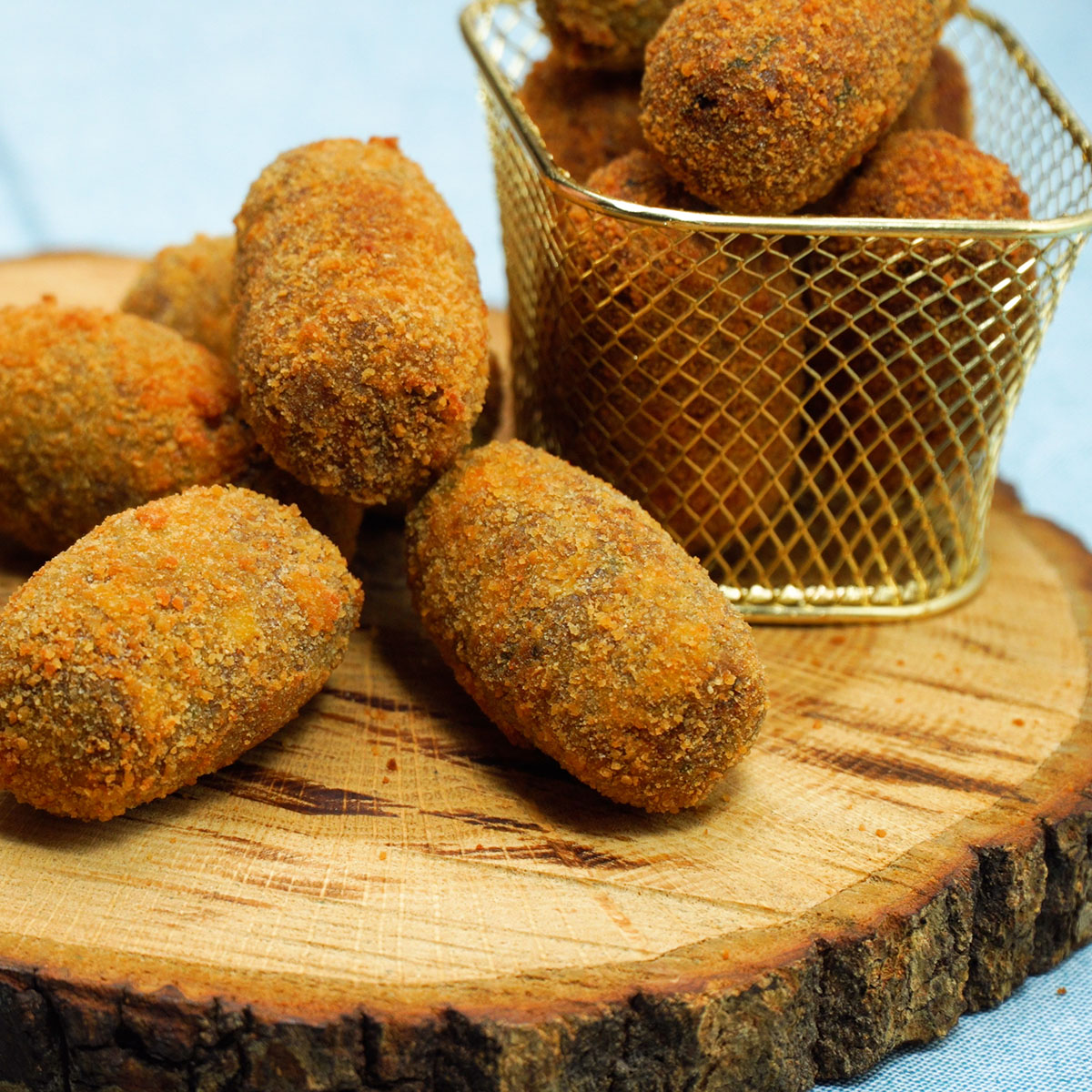 Croquetes de carne escorrendo em papel absorvente, prontos para servir.