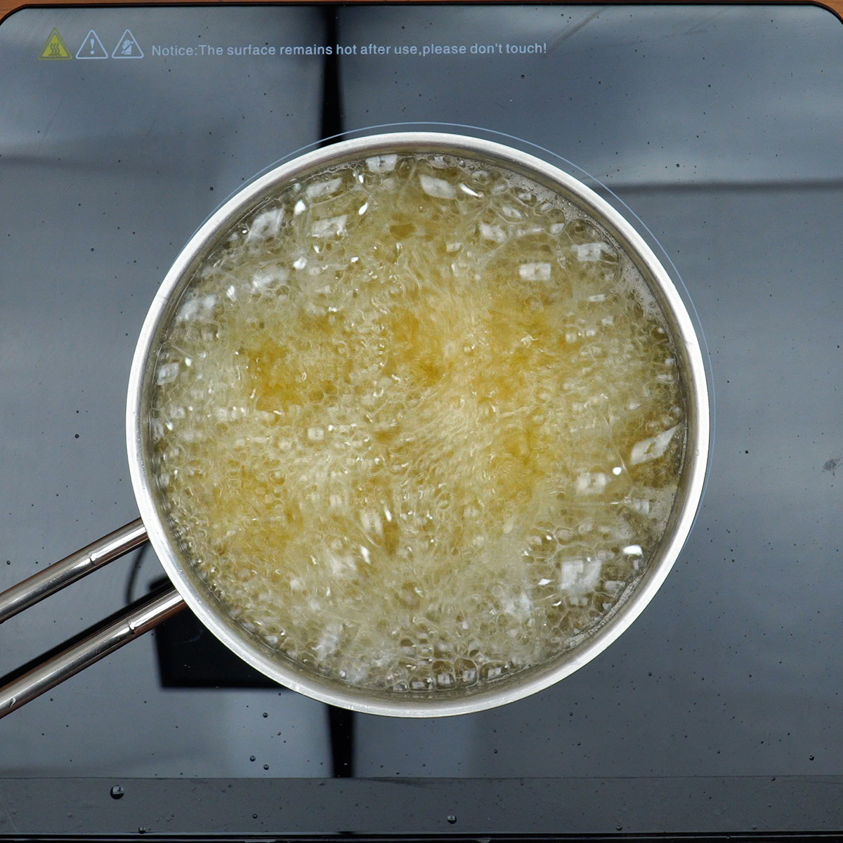 Croquetes de carne sendo colocados para fritar em óleo quente.
