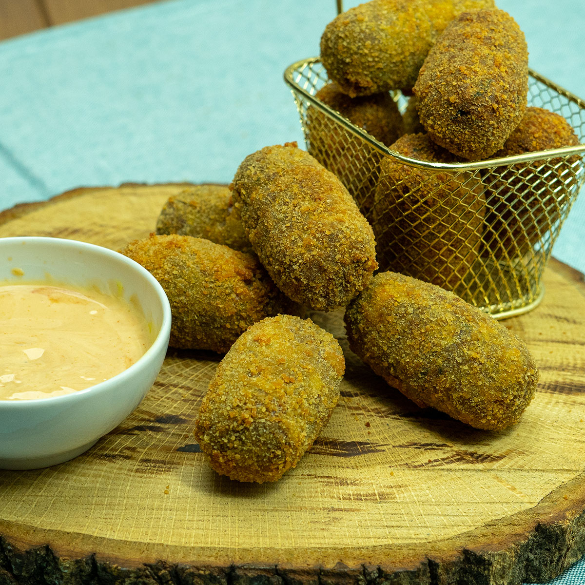 Croquetes de carne prontos sendo servidos com molho.