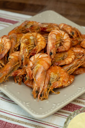 Empratamento camarão com molho de cerveja sendo servido.