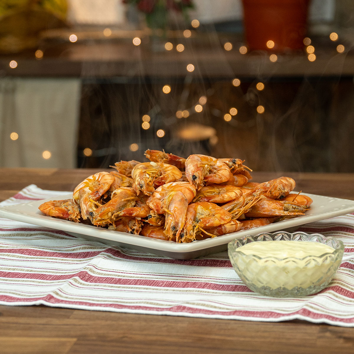 Empratamento de camarão com molho de cerveja sendo servido com molhos.
