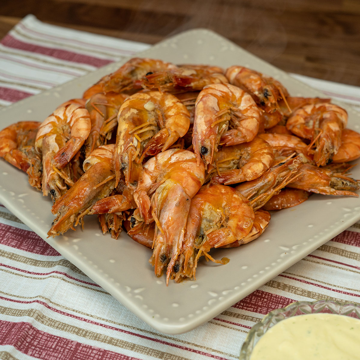 Empratamento camarão com molho de cerveja sendo servido.