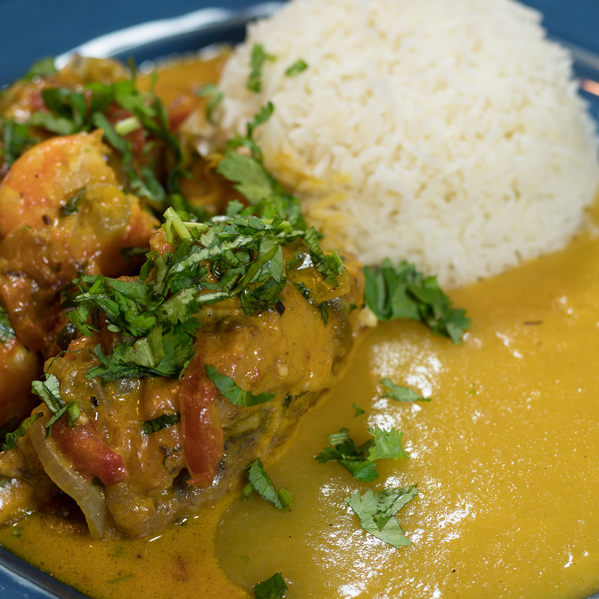 Moqueca de peixe empratada com arroz branco e pirão como acompanhamento.
