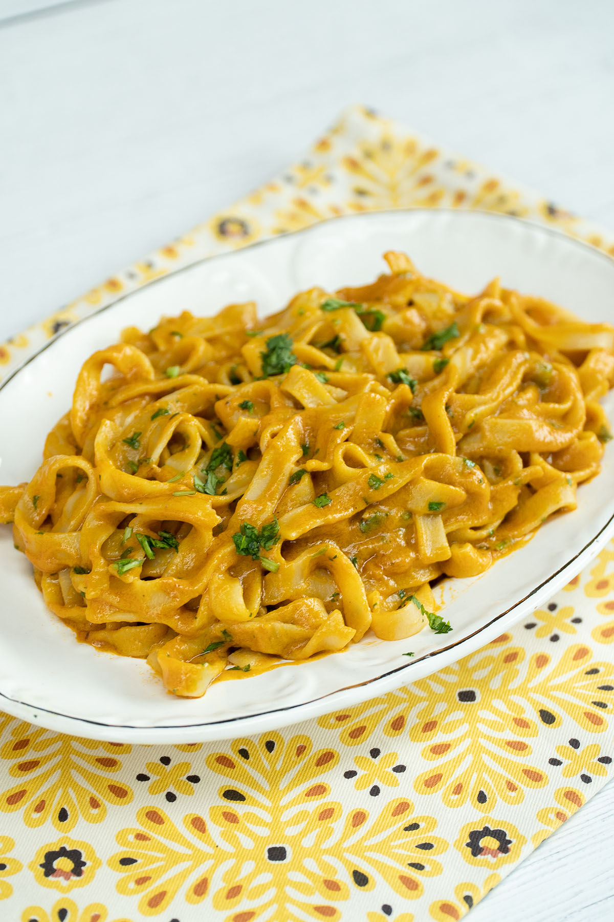 Empratamento de tagliatelle ao molho de camarão finalizado com salsa.