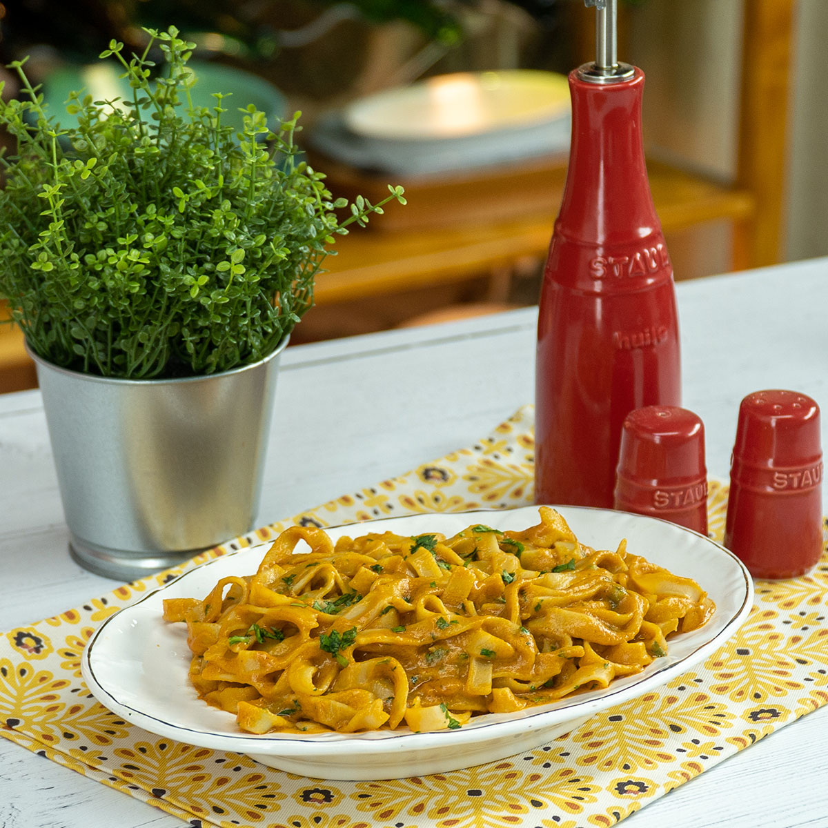 Empratamento de tagliatelle ao molho de camarão finalizado com salsa.