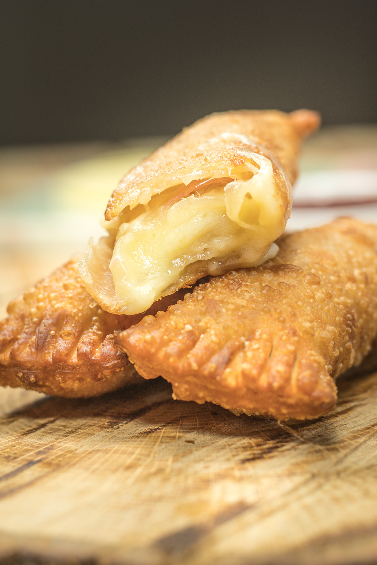Enroladinhos mistos cortados ao meio para mostrar o recheio de presunto e queijo.