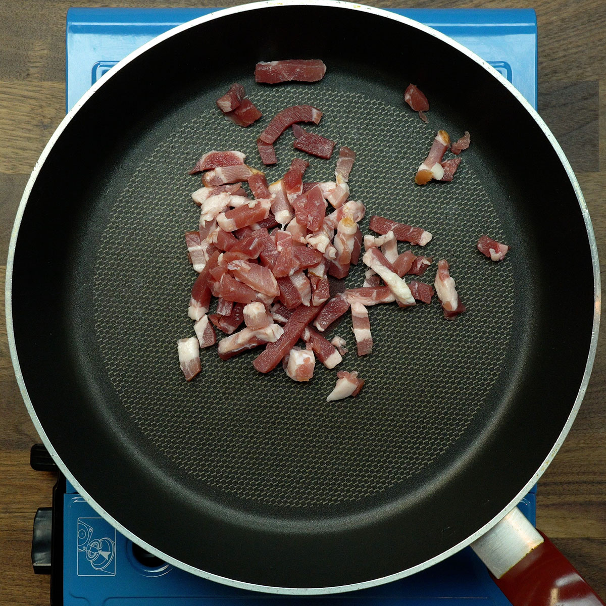 Bacon dourando na frigideira e soltando gordura para o preparo da farofa.