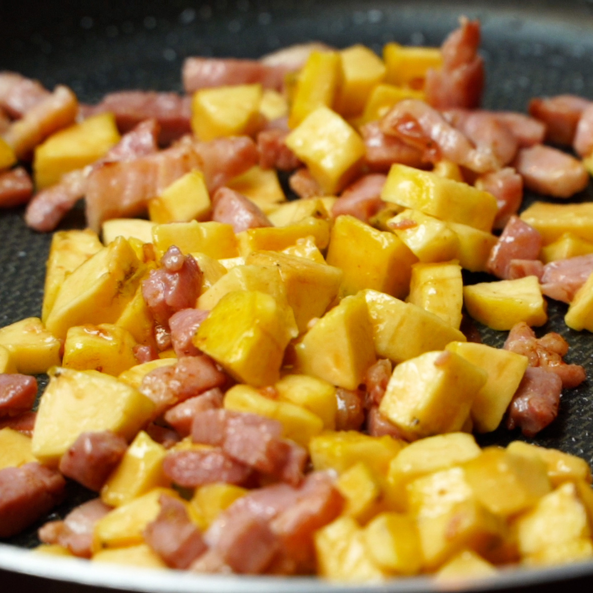 Bacon e banana-da-terra sendo preparados na frigideira.