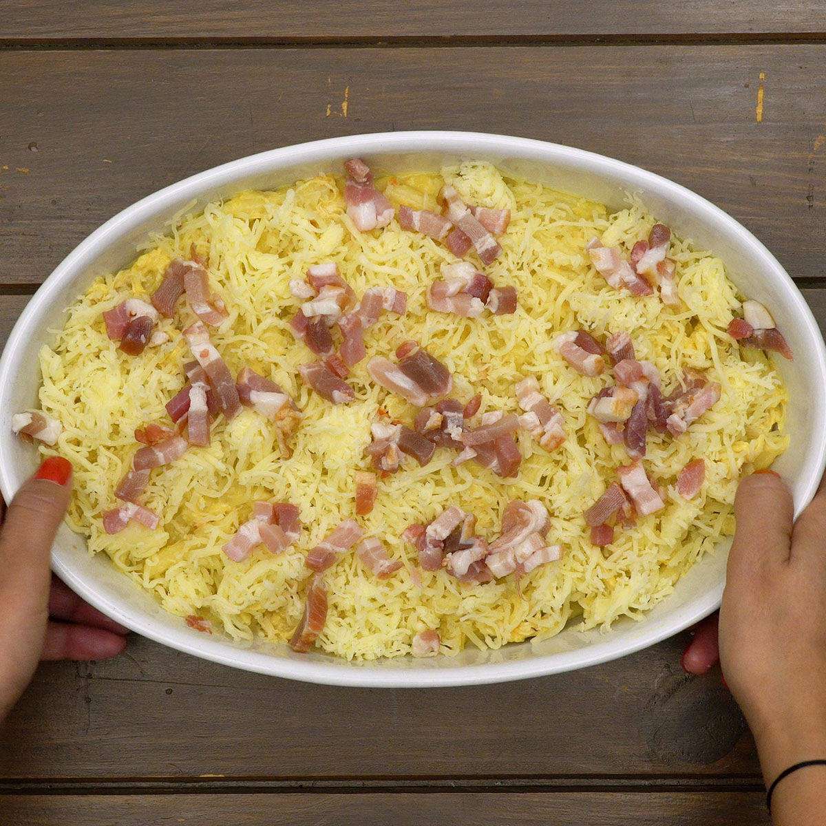 Macarrão gratinado com queijo derretido e bacon dourado.