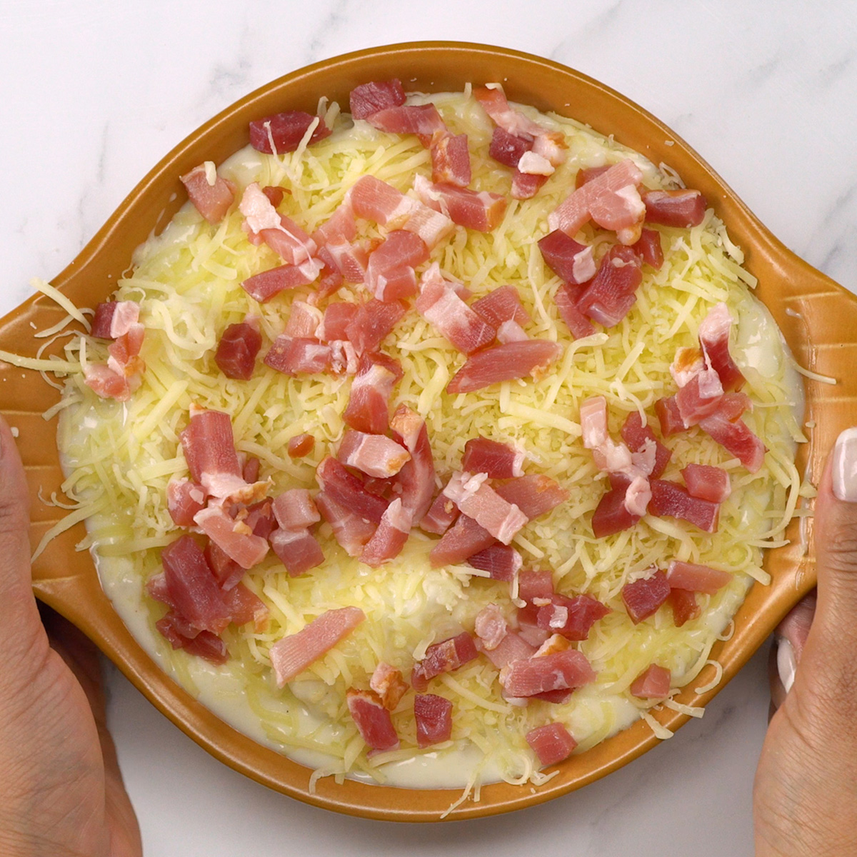 Mandioca gratinada dourada saindo do forno.