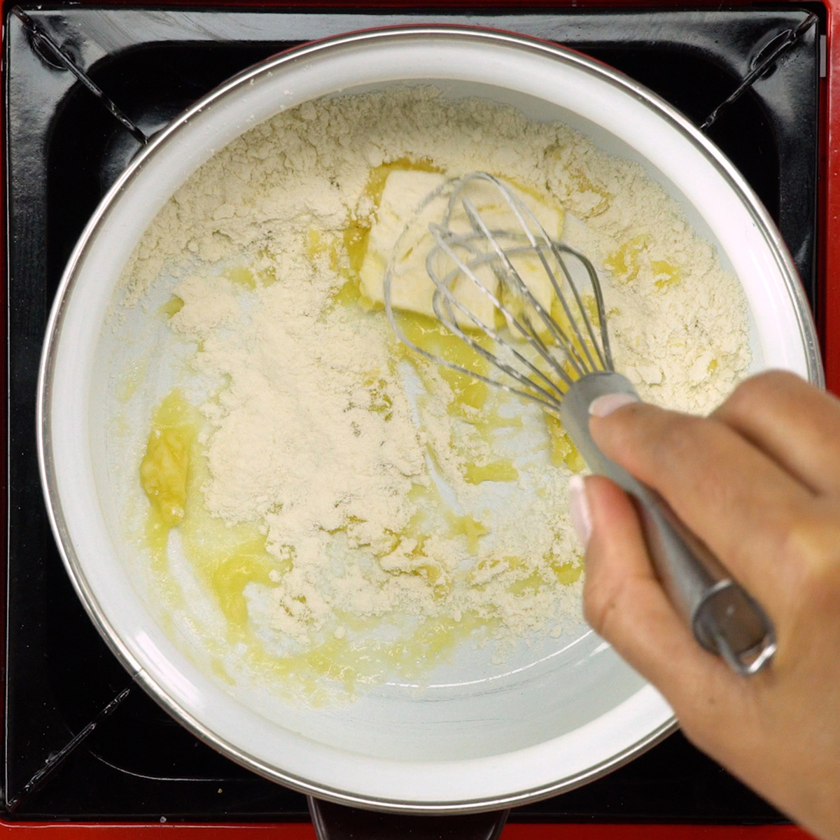 Mistura de manteiga e farinha sendo preparada na panela.