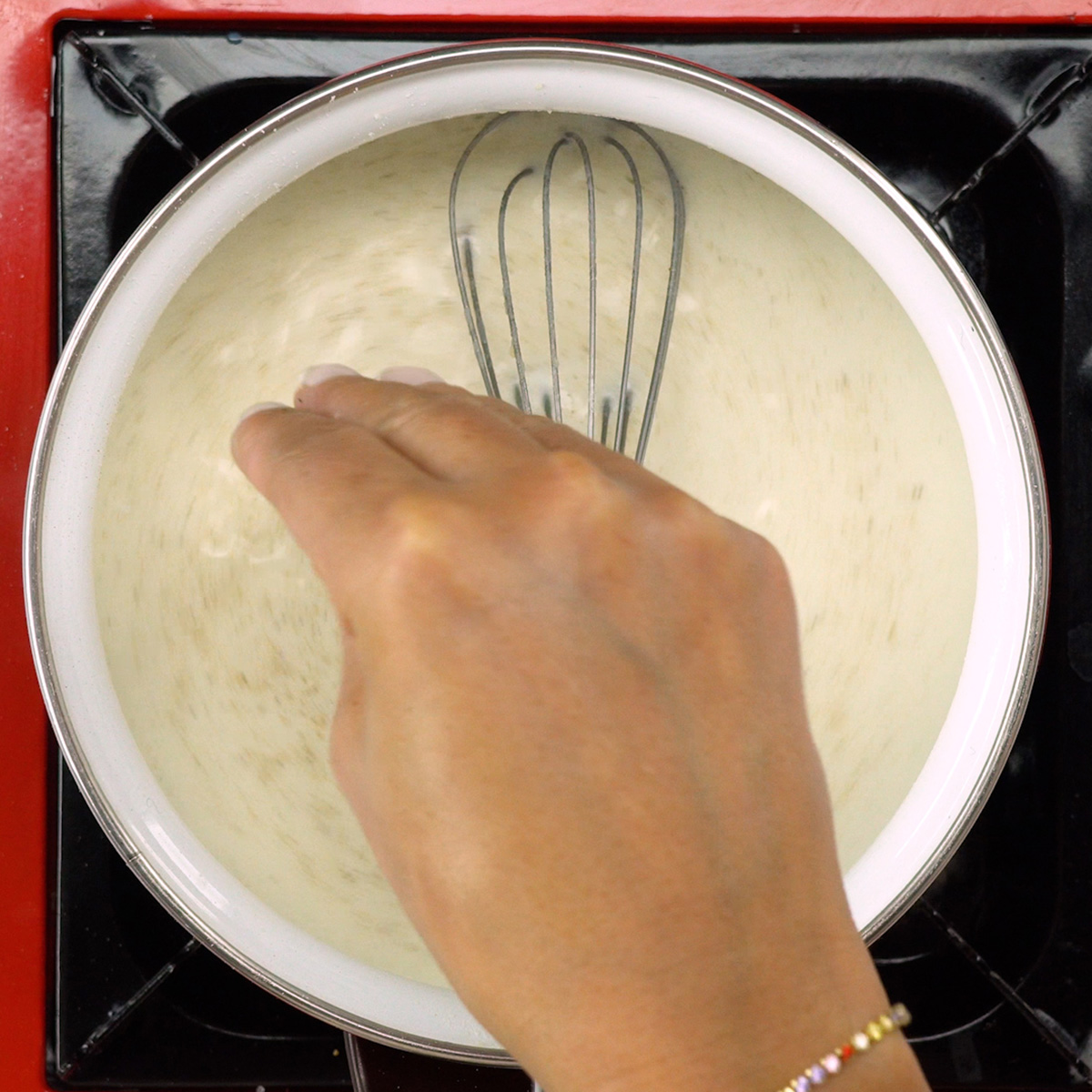 Molho branco sendo temperado com noz-moscada e sal.