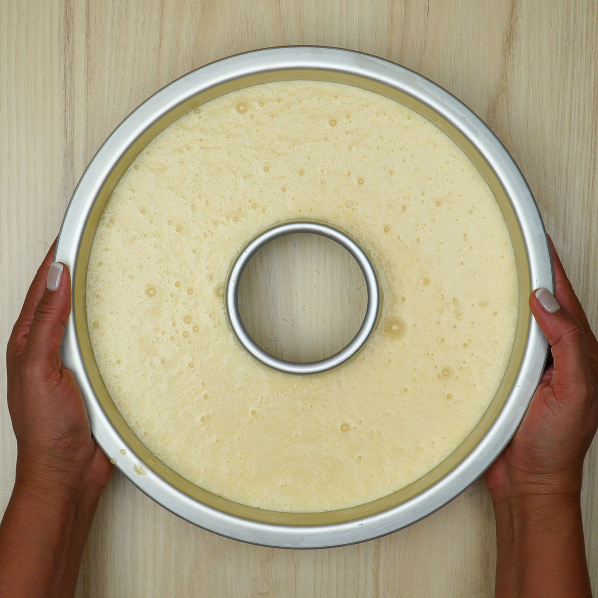 Bolo de coco cremoso no liquidificador sendo levado ao forno.