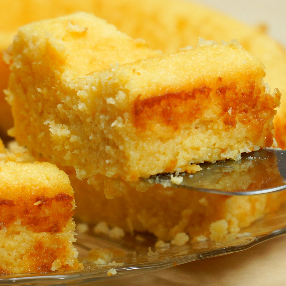Bolo de coco cremoso no liquidificador sendo servido em fatias.