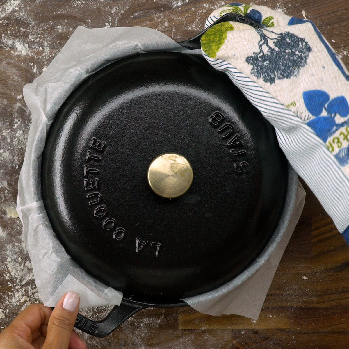 Pão sendo assado em panela tampada dentro do forno quente.