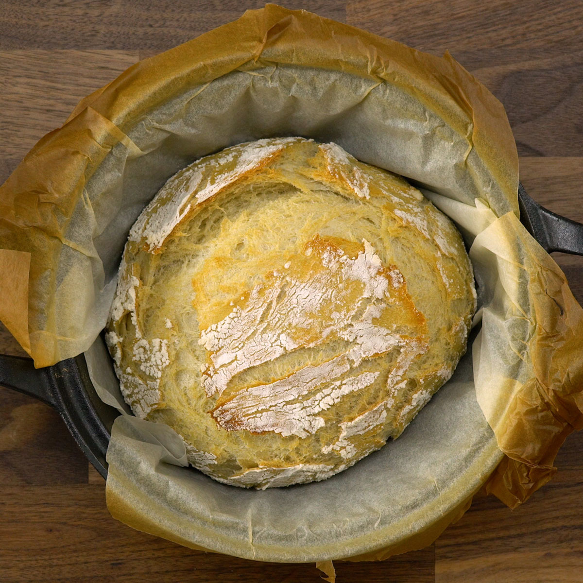 Pão artesanal com crosta dourada sendo finalizado no forno.