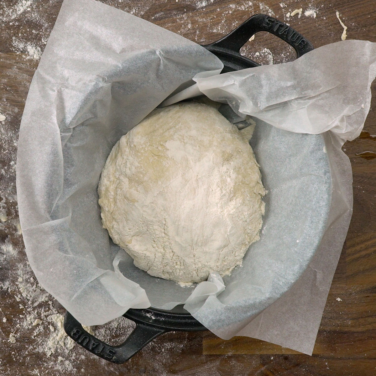 Panela quente com papel-manteiga e farinha, pronta para receber a massa.