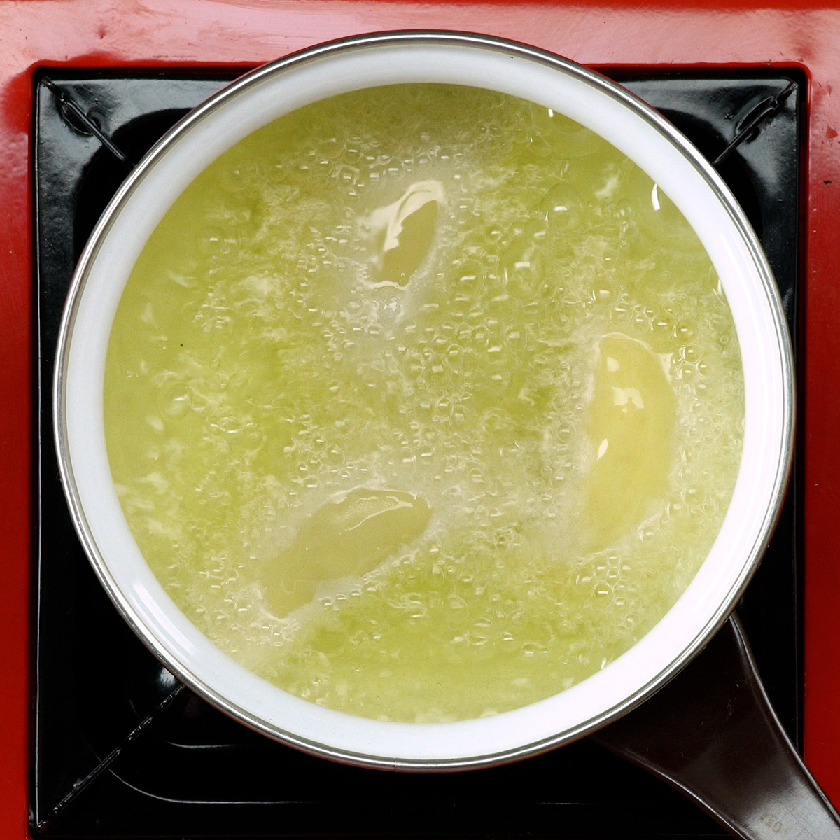 Pastéis fritando em óleo quente até dourarem.