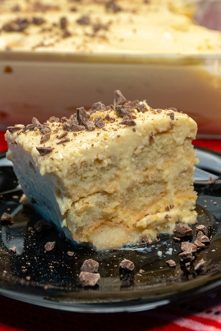 Empratamento pavê de maracujá com pedaços de chocolates sendo servido.