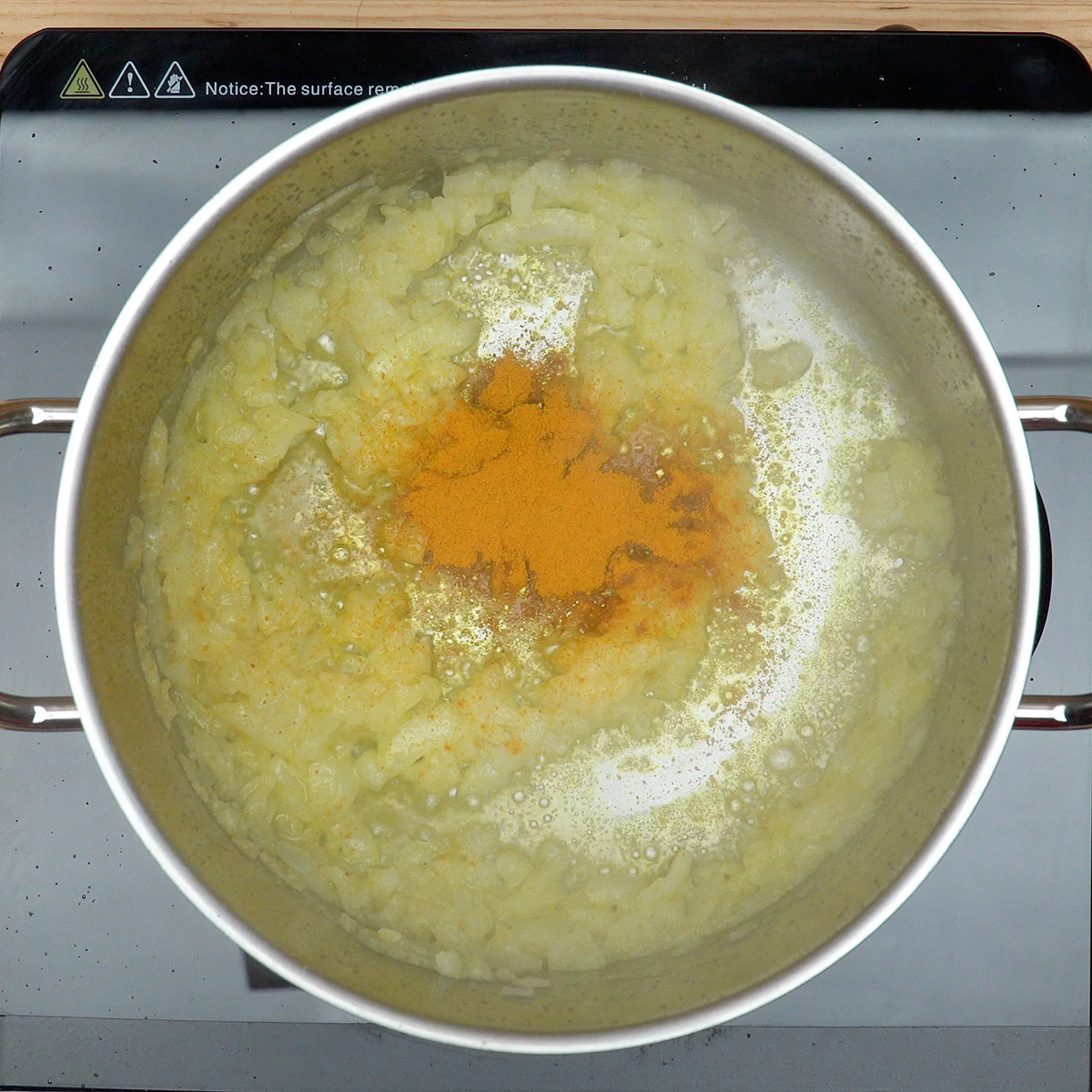 Açafrão sendo misturado ao refogado para dar cor aos pipis de frango.