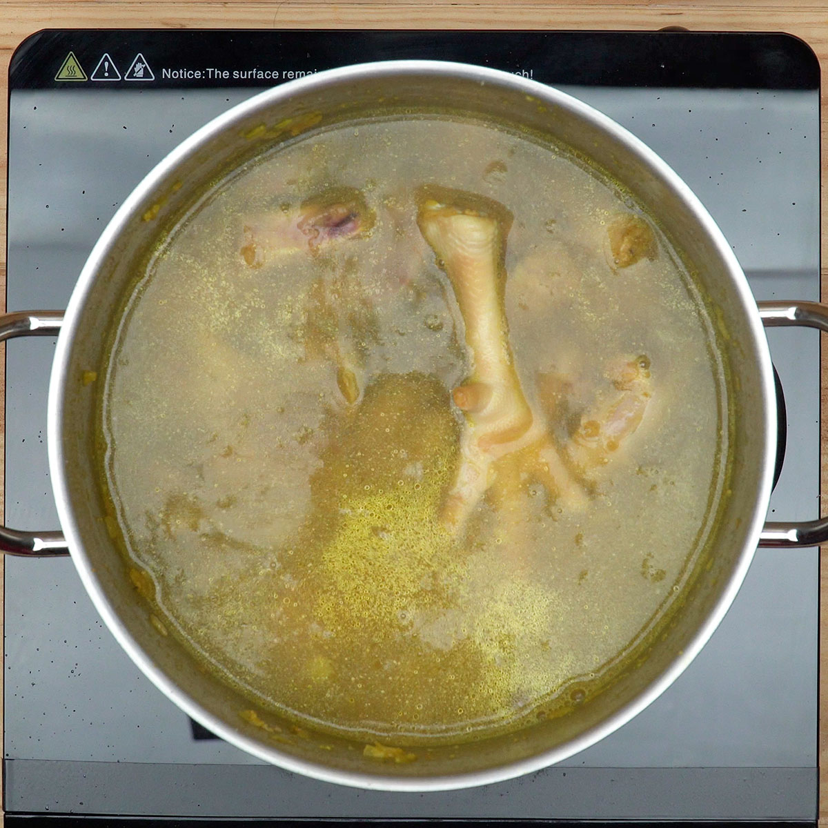 Água sendo adicionada à panela para cozinhar os pipis de frango.
