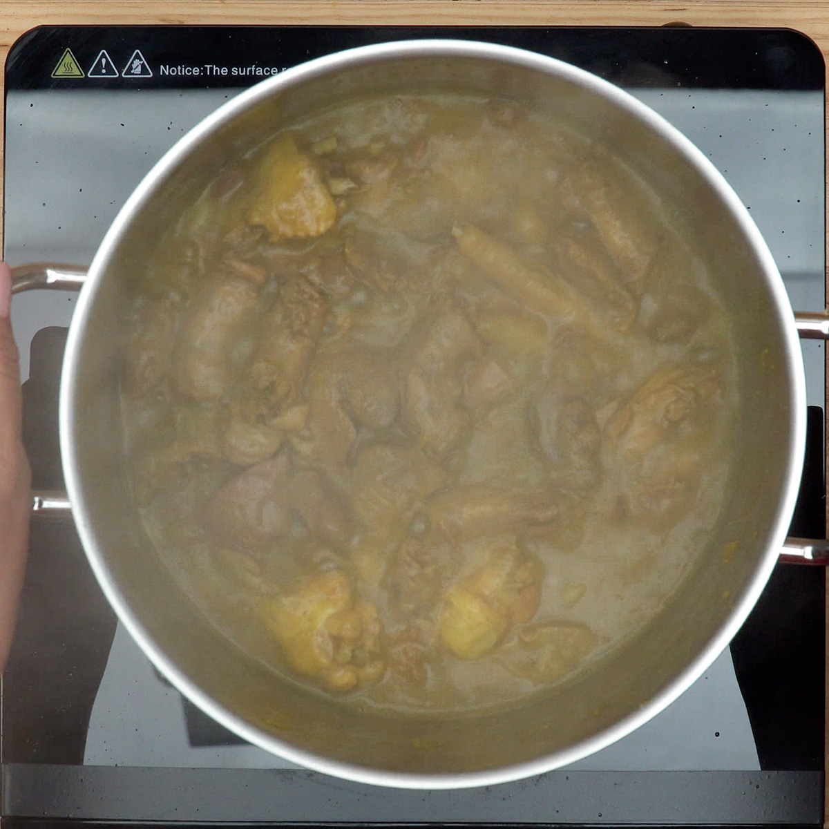 Pipis de frango a cozinhar lentamente com molho encorpado.