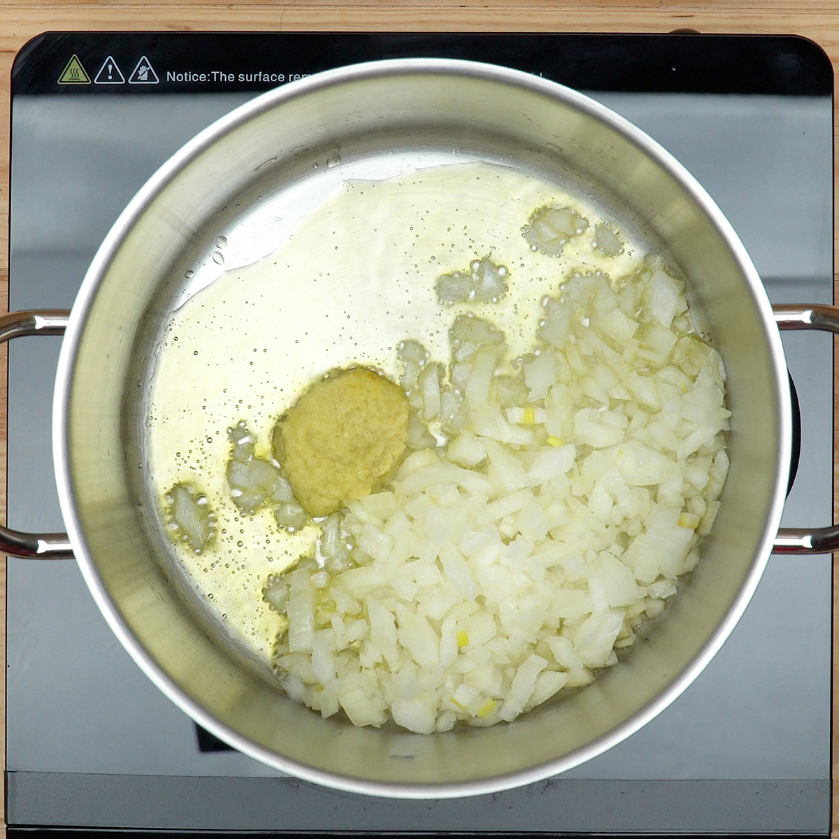 Refogado de cebola e alho em azeite numa panela para pipis de frango.