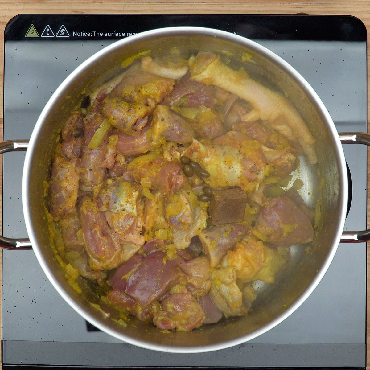 Temperos como cominhos e pimenta sendo adicionados aos pipis de frango.