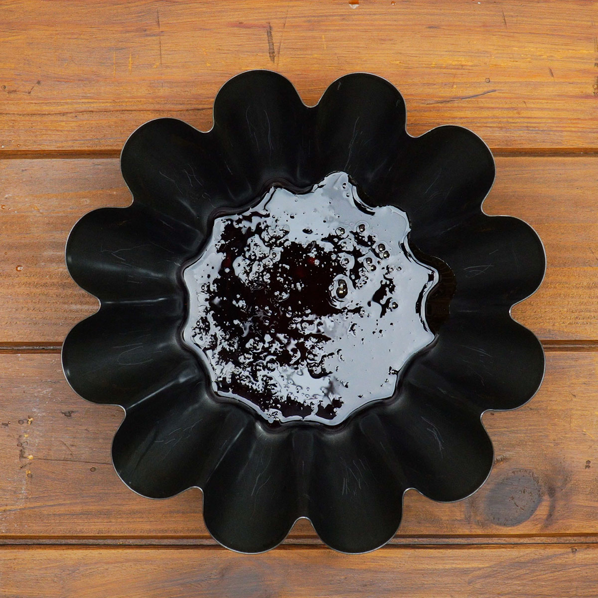 Forma de pudim caramelizada com a calda espalhada no fundo.