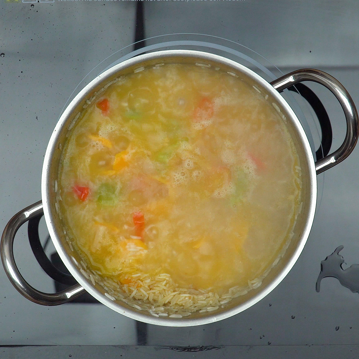 Água sendo adicionada ao arroz com pequi na panela.