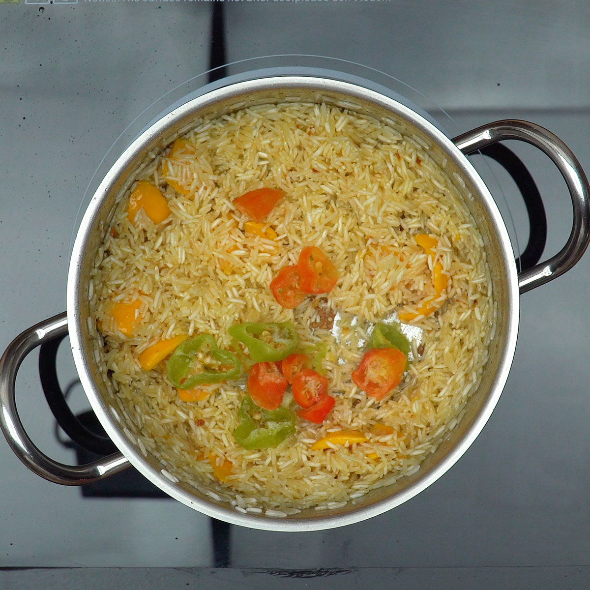 Temperos sendo adicionados ao arroz com pequi.