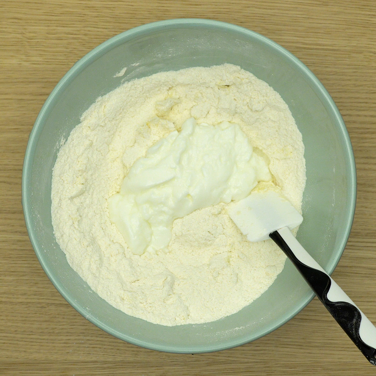 Iogurte sendo incorporado à massa de biscoito caseiro.